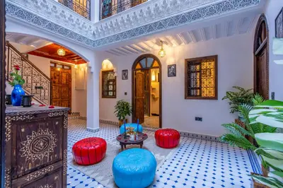 a room with red and blue stools and a table at Riad La Perle Bleue Marrakech in Marrakech