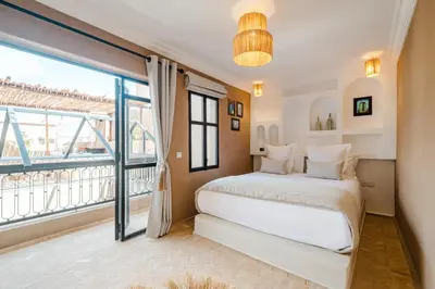 a bedroom with a bed and a large window at Riad Chama 10mn from Jamaa Al Fna in Marrakech