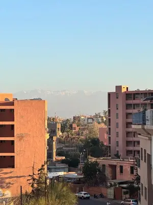 a city with buildings and mountains in the background at Cozy flat in Marrakesh in Marrakech