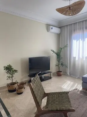 a living room with a tv and a chair and a couch at Cozy flat in Marrakesh in Marrakech