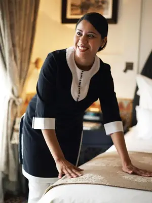 a woman is making a bed in a hotel room at Villa Atlas Dreams in Marrakech