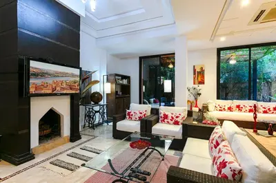 a living room with a fireplace and a tv at Villa Atlas Dreams in Marrakech