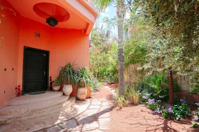 an orange house with potted plants in front of a door at Villa Atlas Dreams in Marrakech
