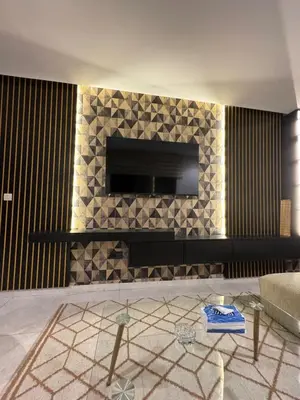 a living room with a fireplace with a television on a wall at Modern and Cozy Apartment Guéliz in Marrakech