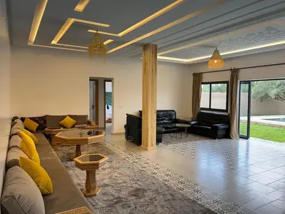 a living room with a couch and a table at Villa JADE with private pool only family in Marrakech