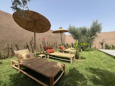 a group of chairs and umbrellas in a yard at Villa JADE with private pool only family in Marrakech