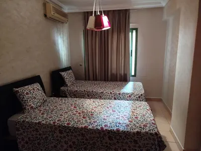a bedroom with two beds and a pink light at Modern 2 Bedroom Appartement in Gueliz in Marrakech