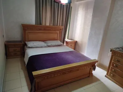 a bedroom with a wooden bed with a purple blanket at Modern 2 Bedroom Appartement in Gueliz in Marrakech