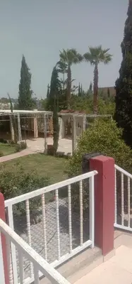 a white fence with a view of a park at nice mini villa with pool in Marrakech