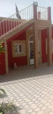 a red house with a balcony on top of it at nice mini villa with pool in Marrakech