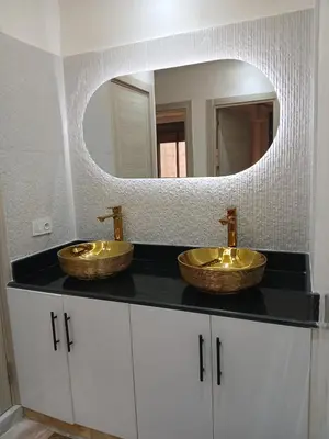 a bathroom with two sinks on a counter with a mirror at Cosy appartement Victor Hugo in Marrakech