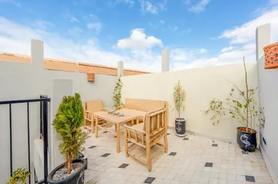 a patio with a table and chairs and plants at Dar mehdi in Marrakech