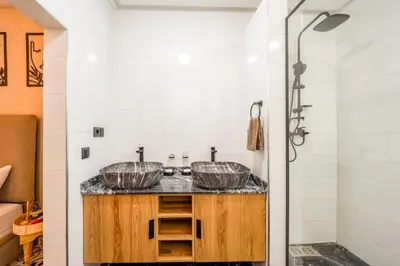 two sinks in a bathroom with a shower at Dar mehdi in Marrakech