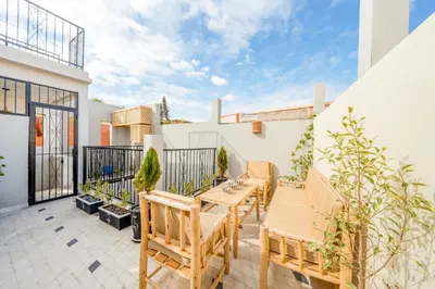 a patio with wooden tables and chairs on a balcony at Dar mehdi in Marrakech