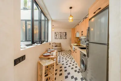 a kitchen with a refrigerator and a table at Dar mehdi in Marrakech