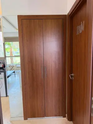 a wooden cabinet with a door in a room at Appartement cosy pour 4 personnes in Marrakech