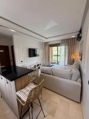 a living room with a couch and a bed at Appartement cosy pour 4 personnes in Marrakech