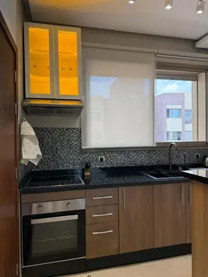 a kitchen with brown cabinets and a stove and a window at Appartement cosy pour 4 personnes in Marrakech