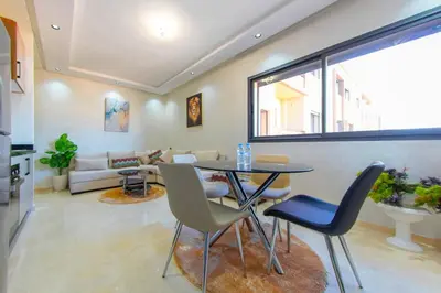 a living room with a table and chairs at New apartment with pool in Marrakech