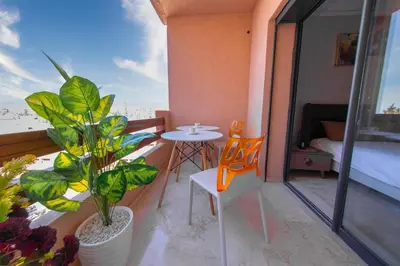a balcony with a table and chairs and a bed at New apartment with pool in Marrakech