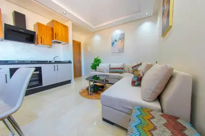 a living room with a couch and a kitchen at New apartment with pool in Marrakech