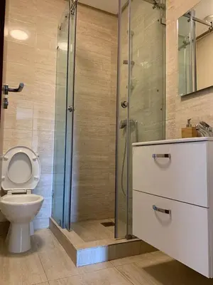 a bathroom with a toilet and a glass shower at luxury, 4 pools et golf in prestigious in Marrakech