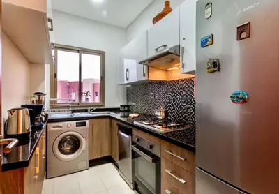 a kitchen with a stainless steel refrigerator and a dishwasher at luxury, 4 pools et golf in prestigious in Marrakech