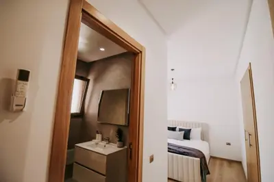 a bedroom with a bed and a sink and a mirror at Spacious 3BR with Prime Location in Marrakech