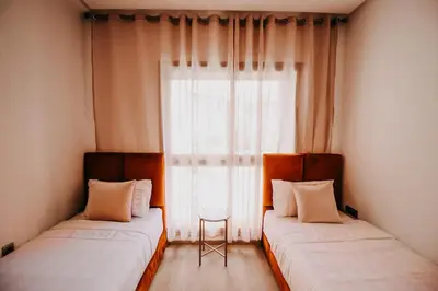 two beds in a room with a window at Spacious 3BR with Prime Location in Marrakech