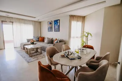 a living room with a table and chairs at Spacious 3BR with Prime Location in Marrakech
