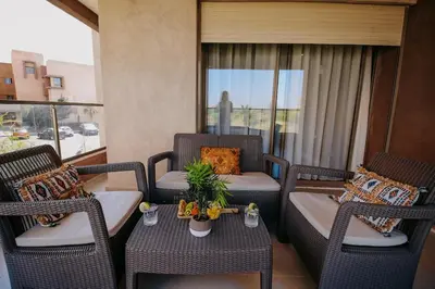 a balcony with wicker chairs and a table at Spacious 3BR with Prime Location in Marrakech