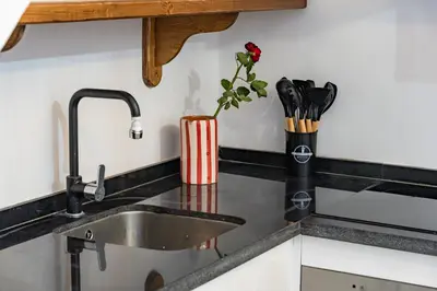 a kitchen counter with a sink and a vase with a flower at Riad privatif 2 Chambres, Jacuzzi Proche des Palais in Marrakech