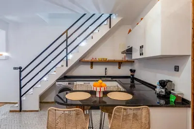 a kitchen with a table and a staircase at Riad privatif 2 Chambres, Jacuzzi Proche des Palais in Marrakech
