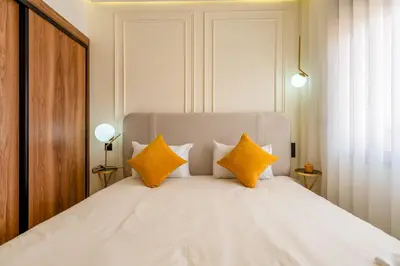a bedroom with a large white bed with yellow pillows at Le Darna - Marrakech Victor Hugo - 2prs - Wifi in Marrakech