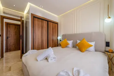 a bedroom with a large white bed with yellow pillows at Le Darna - Marrakech Victor Hugo - 2prs - Wifi in Marrakech