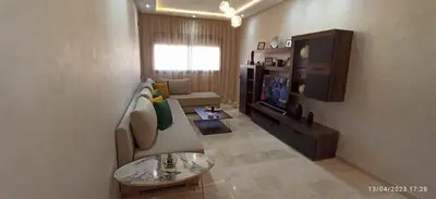 a living room with a couch and a tv at Magnifique appartement avec piscine à Gueliz in Marrakech