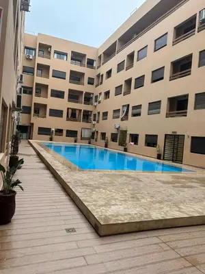 a swimming pool in front of a building at Magnifique appartement avec piscine à Gueliz in Marrakech