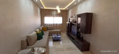 a living room with a couch and a television at Magnifique appartement avec piscine à Gueliz in Marrakech