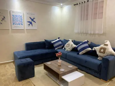a living room with a blue couch and a table at Cosy gem in the heart of marrakech in Marrakech