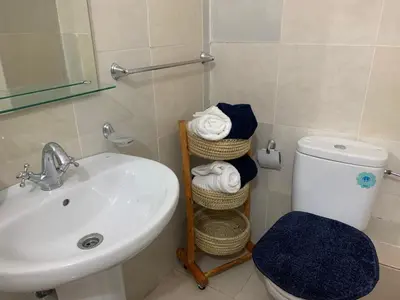 a bathroom with a sink and a toilet and towels at Cosy gem in the heart of marrakech in Marrakech