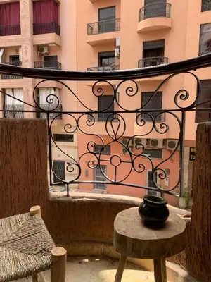 a balcony with a table and a building at Cosy gem in the heart of marrakech in Marrakech
