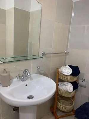 a bathroom with a sink and a mirror and towels at Cosy gem in the heart of marrakech in Marrakech
