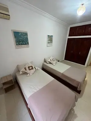 two beds in a white room with a window at Cosy gem in the heart of marrakech in Marrakech