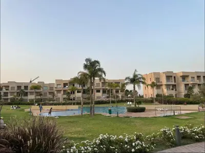 a resort with a pool and palm trees and buildings at Prestigia Argane Jubaea Marrakech in Marrakech
