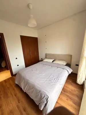 a bedroom with a large white bed and wooden floors at Prestigia Argane Jubaea Marrakech in Marrakech