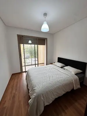 a bedroom with a large bed and a large window at Prestigia Argane Jubaea Marrakech in Marrakech