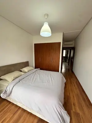 a bedroom with a large bed with a wooden headboard at Prestigia Argane Jubaea Marrakech in Marrakech