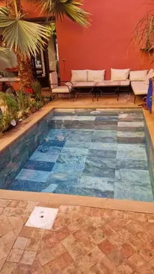 a swimming pool in the middle of a patio at Riad Rose Jade Marrakech in Marrakech