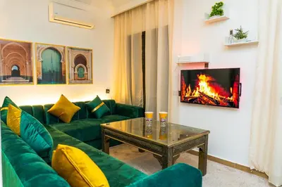 a living room with a green couch and a fireplace at Appartement Moderne à Marrakech in Marrakech