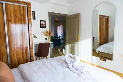 a bedroom with a bed with white sheets and a mirror at Appartement Moderne à Marrakech in Marrakech